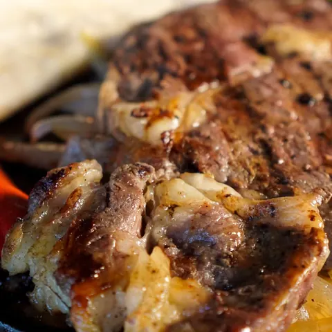 Corte al carbón con salchicha asada y cebolla